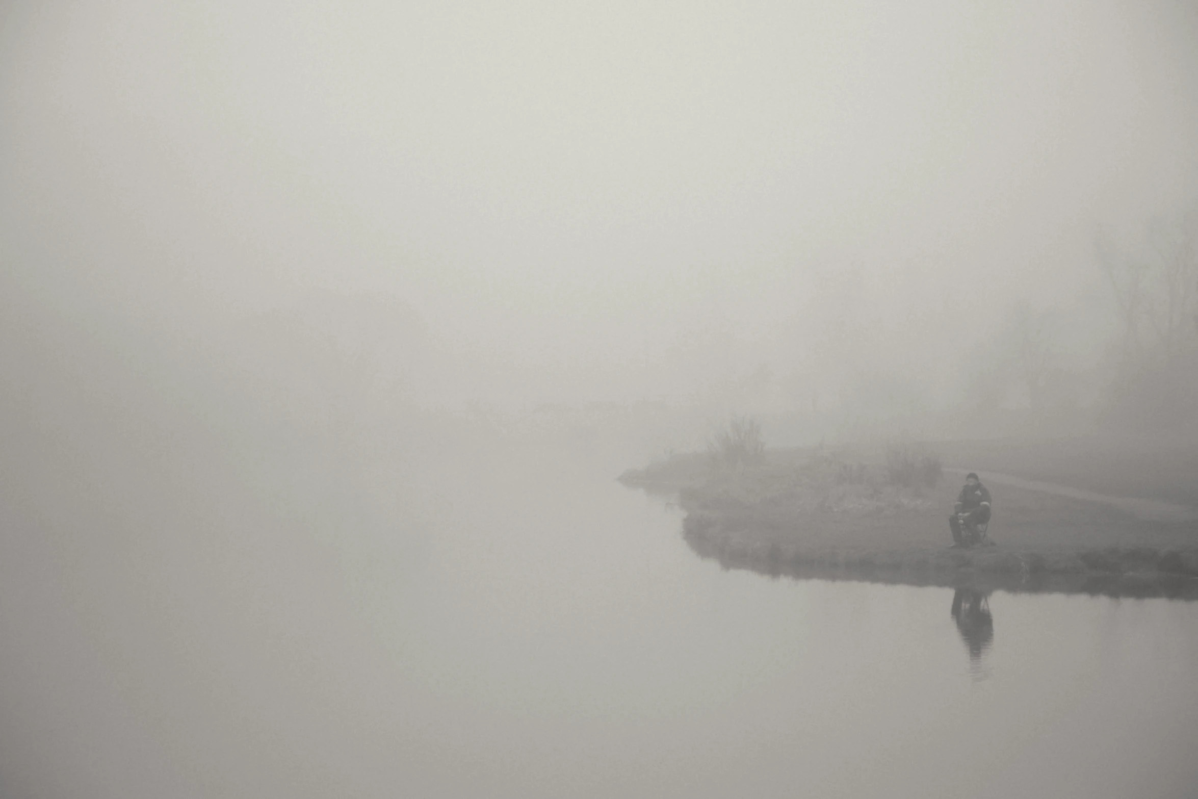 a man on a dock stands in front of a lake