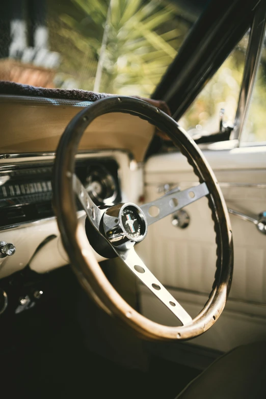 the dashboard of a classic car with steering wheel and leather