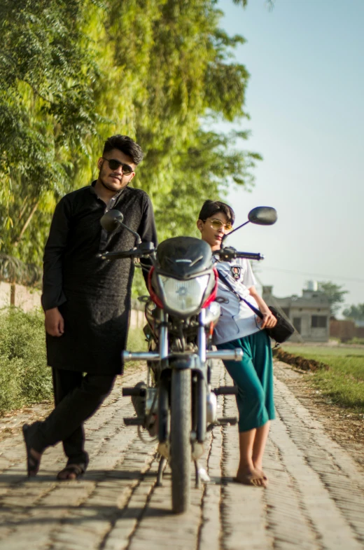 a man and a woman standing near a motorcycle