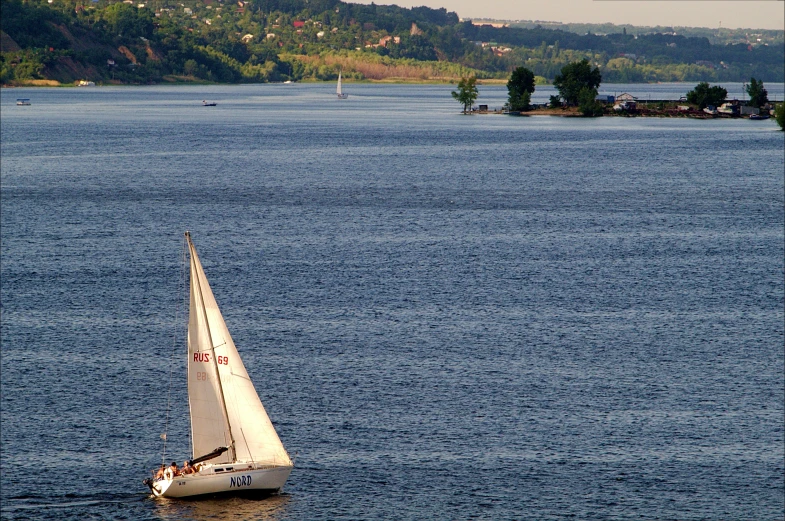 a white sailboat on blue water near shore