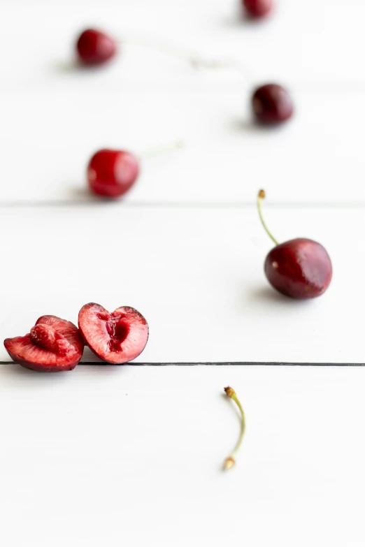 a close up of some cherries on a white surface