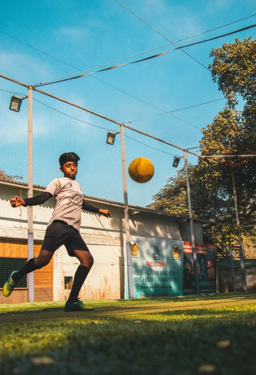 man catching the ball on the grassy field near the net