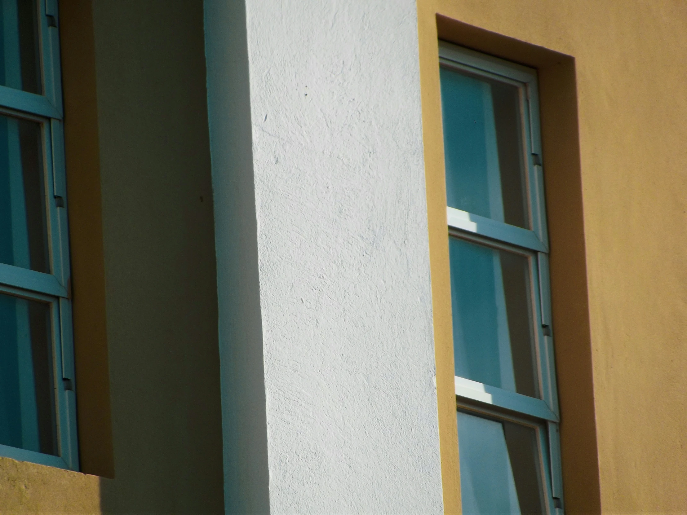 there is a small blue bird perched on a yellow building