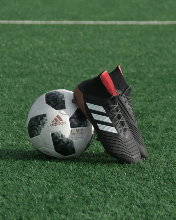 a soccer ball and a black and grey shoe on the grass