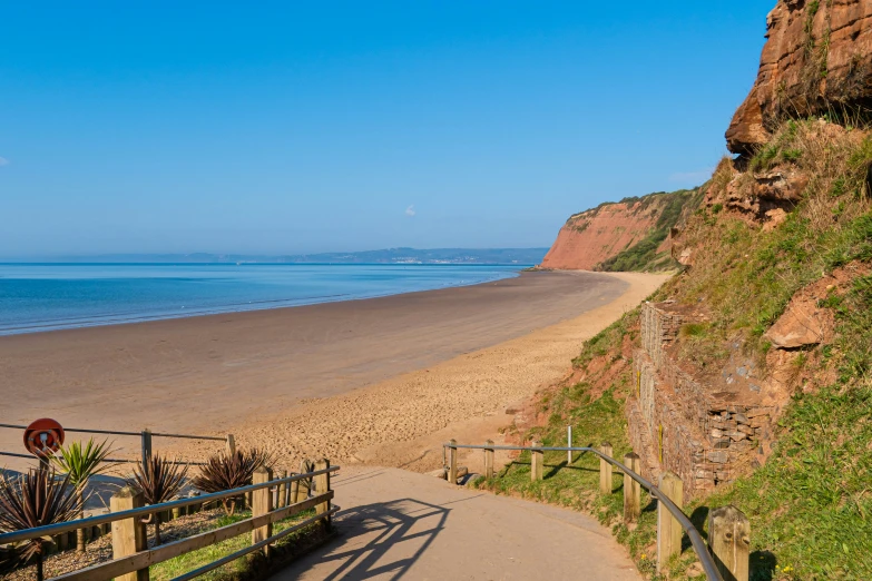 a boardwalk and path at the side of the beach