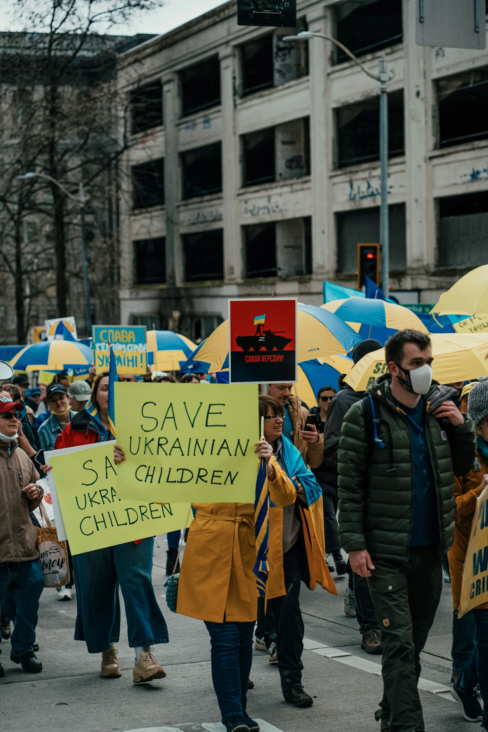 people are holding yellow signs while walking down the street