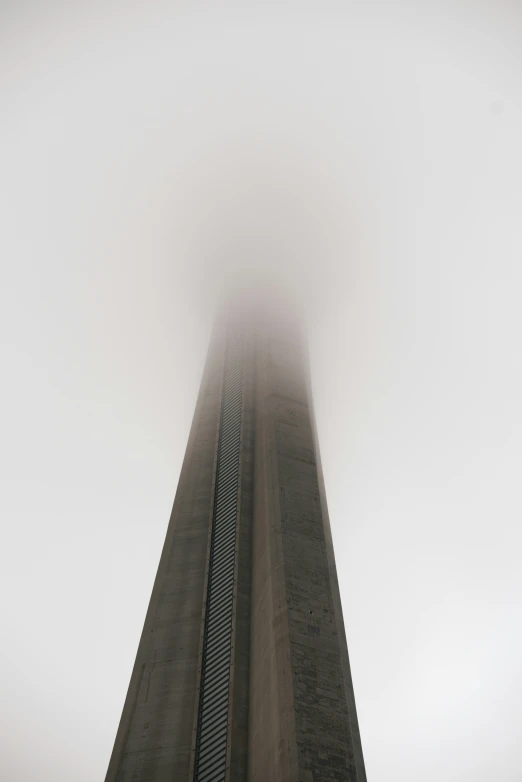 the obelisk tower is standing in front of fog