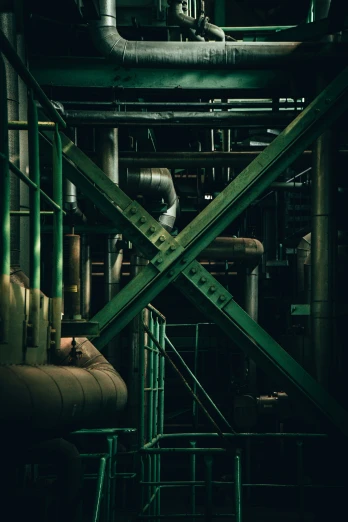 a dark room filled with green pipes and lots of pipe