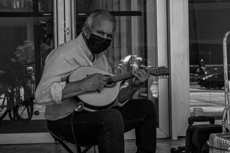 the man with mask is playing his guitar
