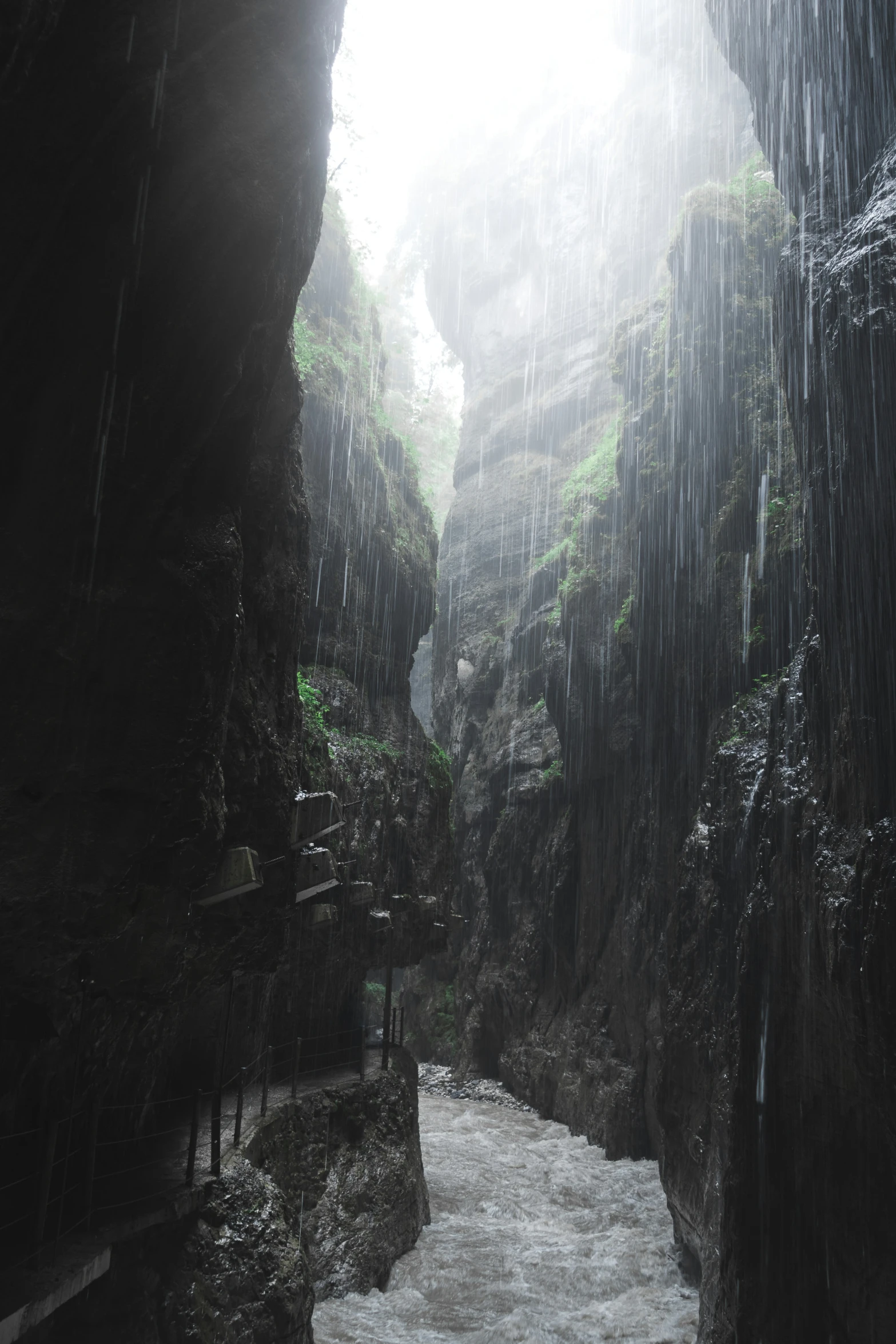 a river running through a very tall stone cave