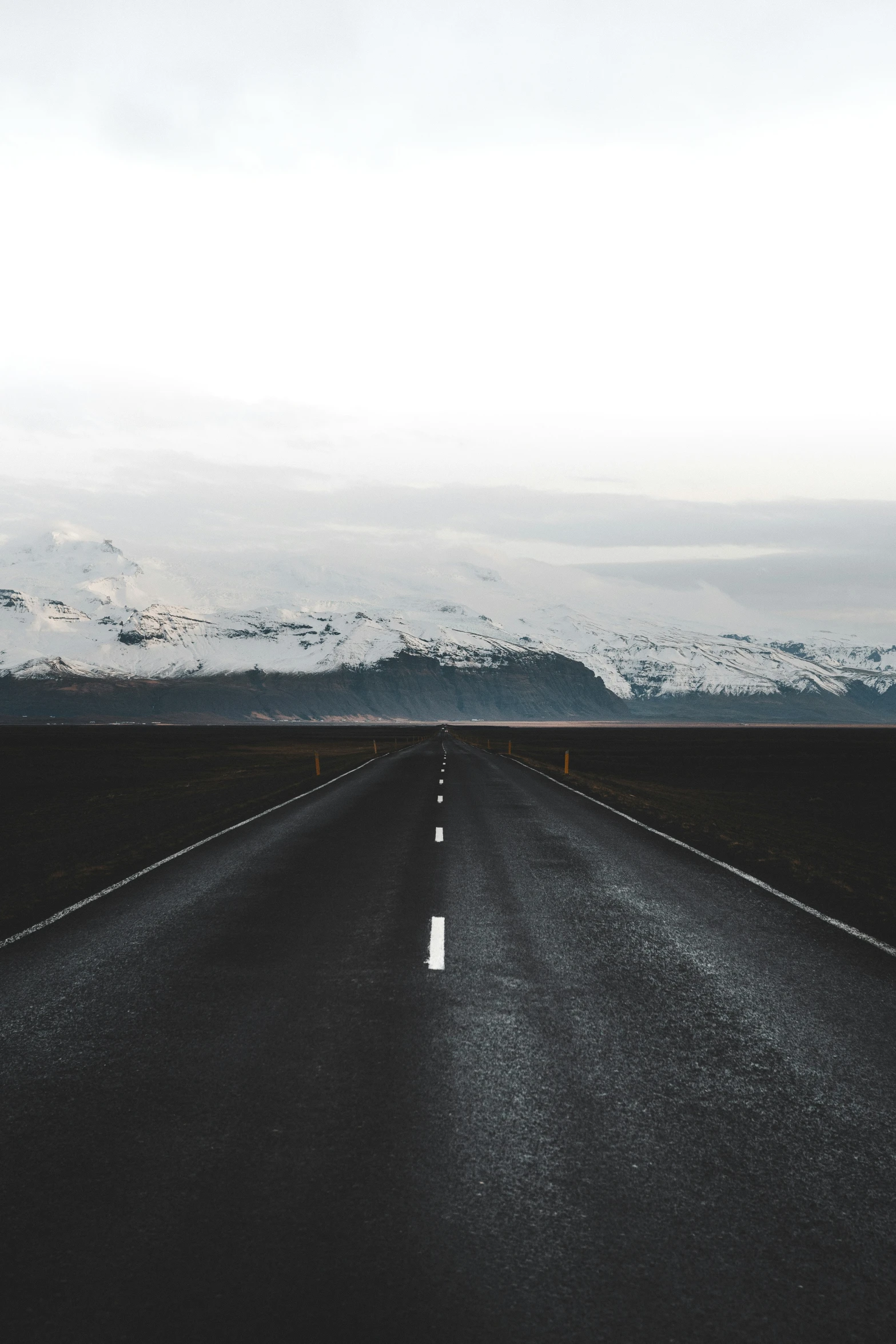 an empty road with mountains in the background