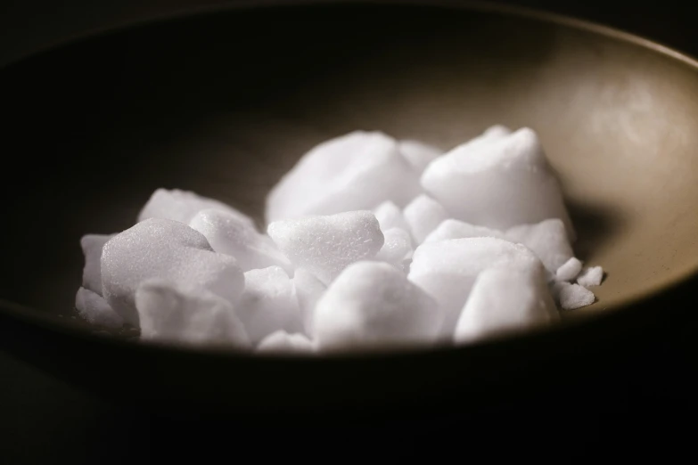 a metal bowl filled with white sugar