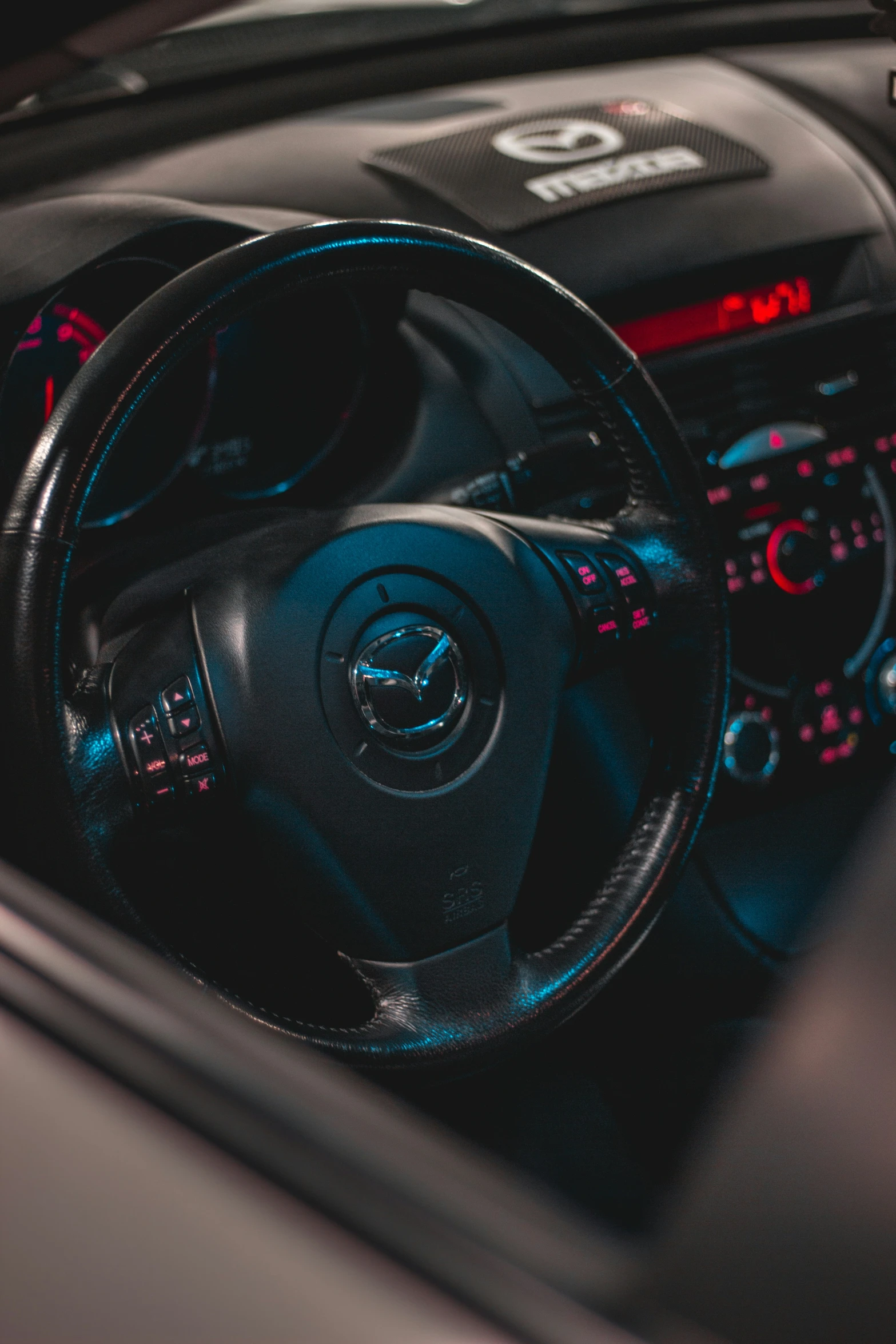 a car dashboard and steering wheel, which has blue lighted numbers on it