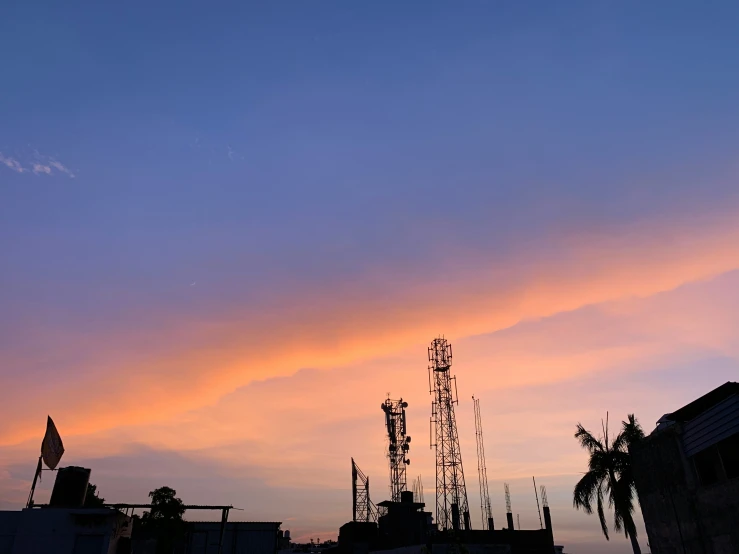 the sky is filled with a bright sunset, and there are tall palm trees