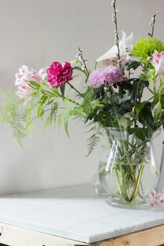 several colorful flowers are in a glass vase