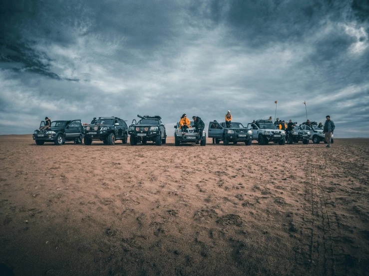 five pickup trucks and a few police cars in the desert