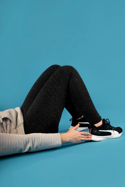 a woman laying on the floor next to her tennis shoe