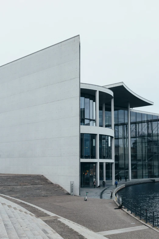 the building has a curved design near the water