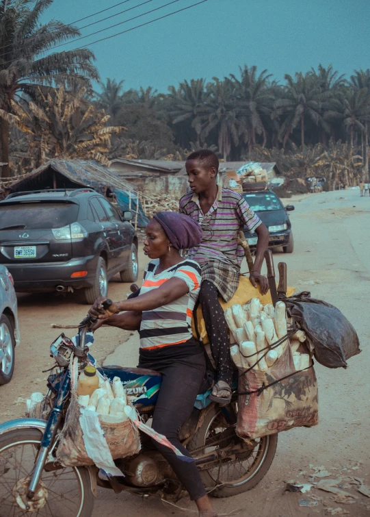 an african man and woman ride on a motorbike