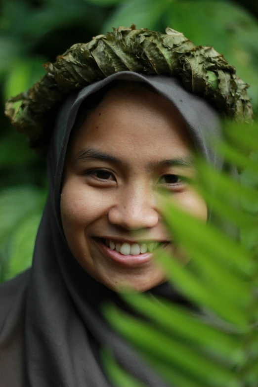 a close up of a person smiling wearing a shawl