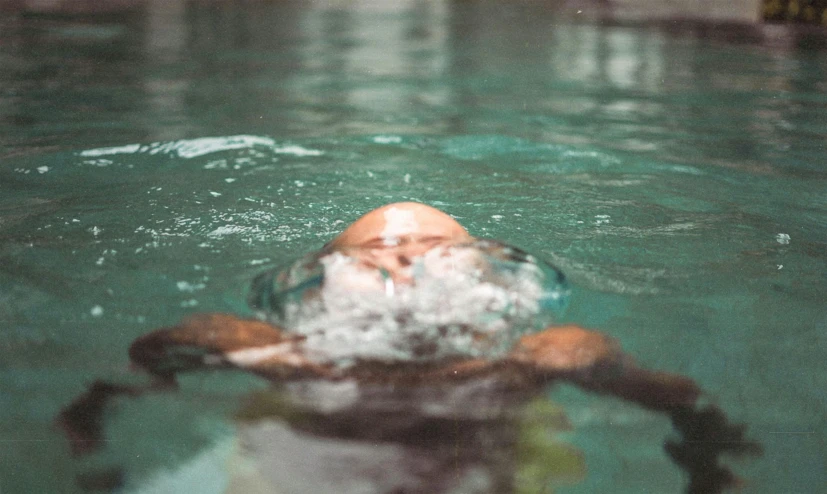 someone in the water is swimming and taking a picture