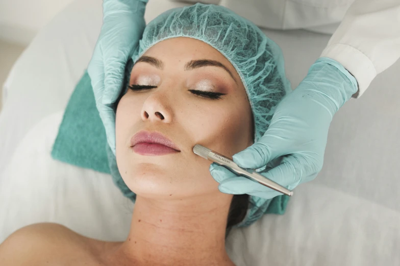 a female receiving facial hair transplant from another woman