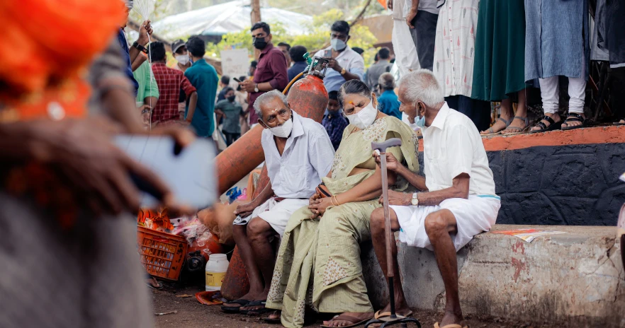 several people sitting and walking around in a marketplace