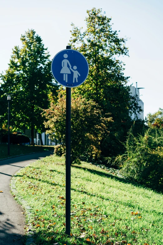 there is a blue sign that says to walk on the grass