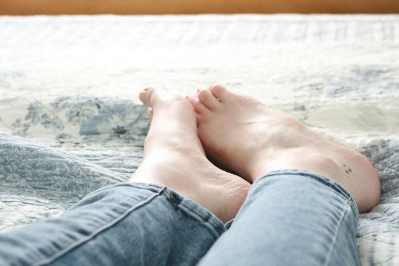 a person with very bare feet on a bed