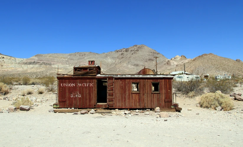 an old abandoned building with mountains in the background