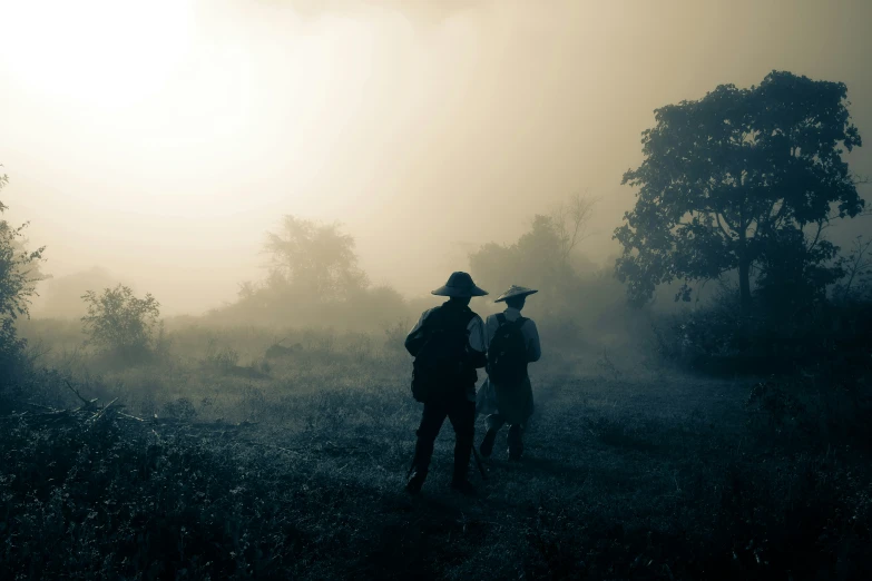 a couple of men are standing in the fog