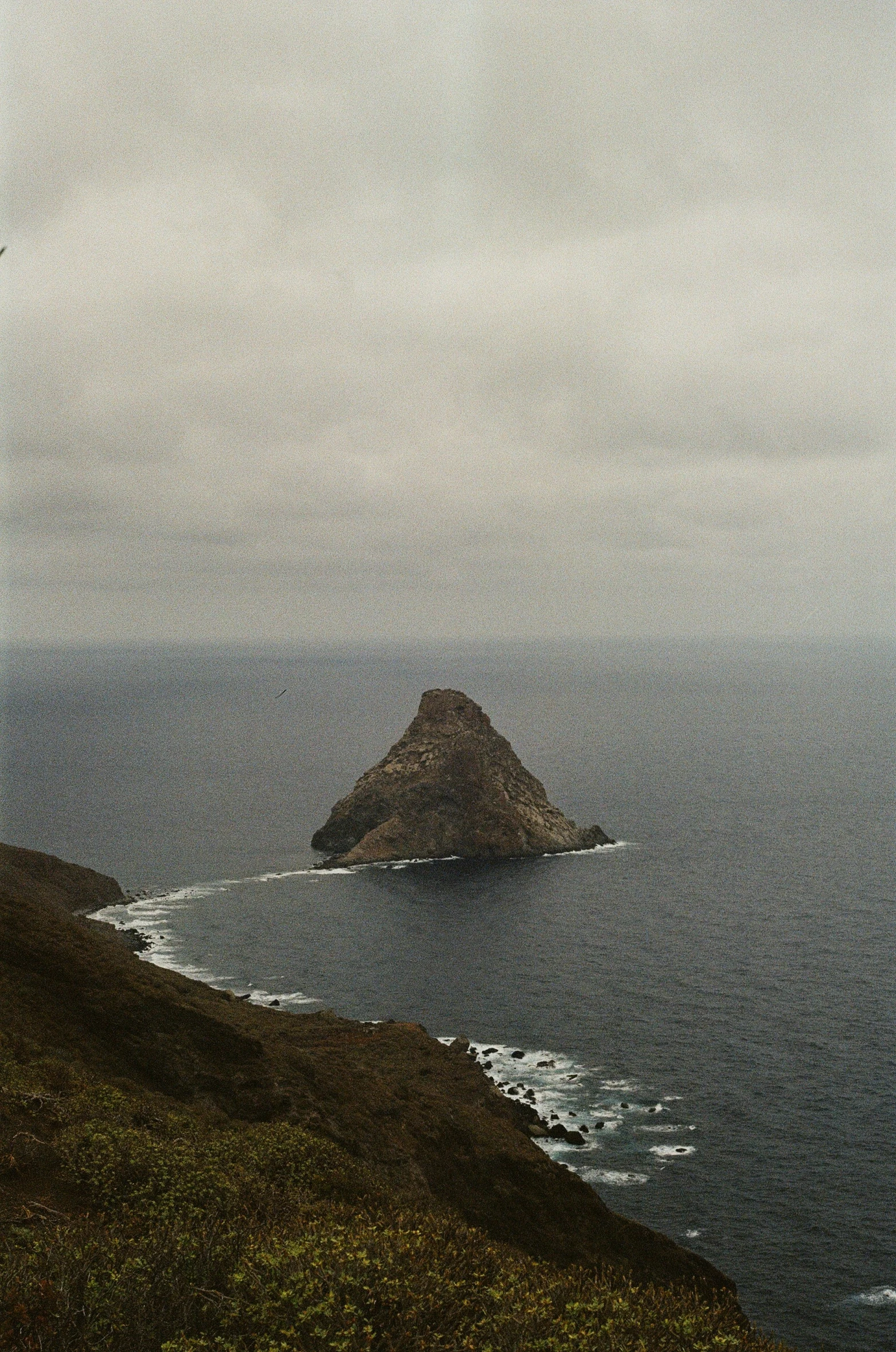 a dark, dreary island with the ocean in front