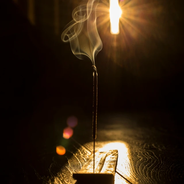 a cup of incense sticks burning while it is dark