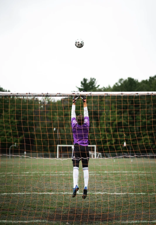 person on field playing soccer on a cloudy day