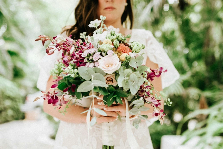 a bride holding a bouquet made with floral