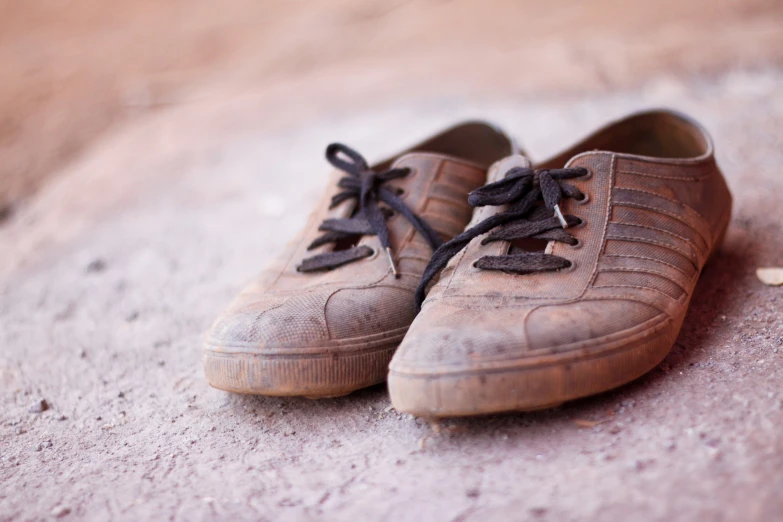 shoes are left out on the concrete, one is worn