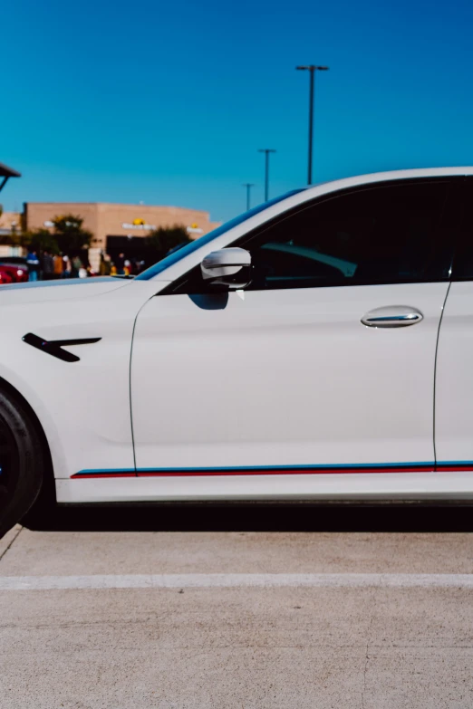 a white bmw parked in a parking lot