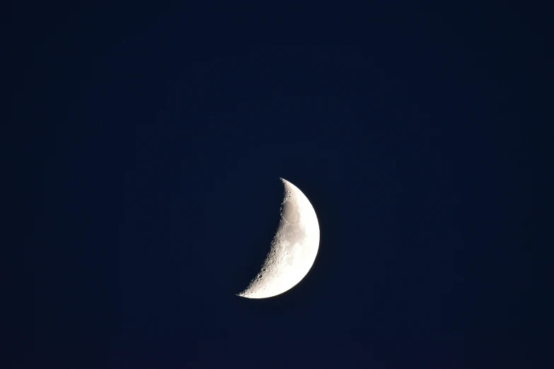 a half - moon is seen through the dark night sky