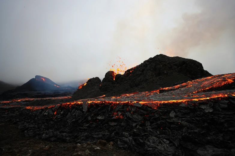 a fire trail is lit up in the distance, with rocks on one side and rocks all along the same wall