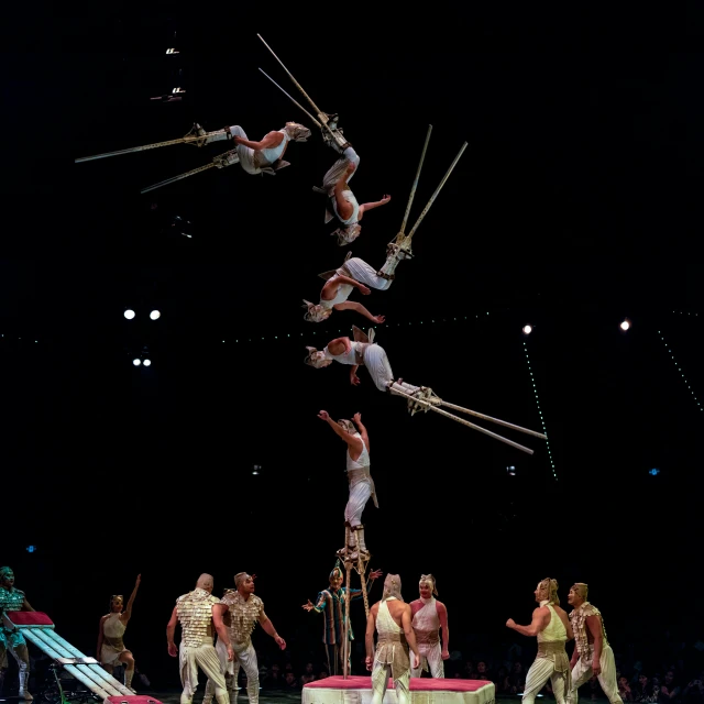 a group of men standing around one man doing acrobatic