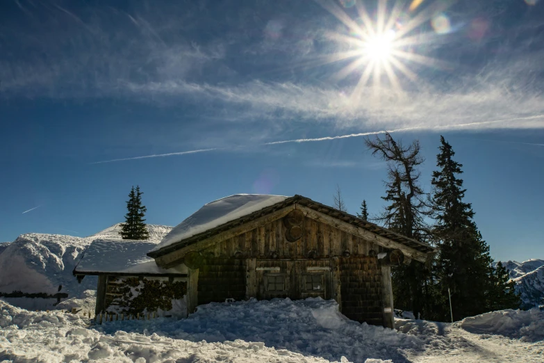 a snowy mountain scene is in the foreground, with a barn, surrounded by snow covered evergreens