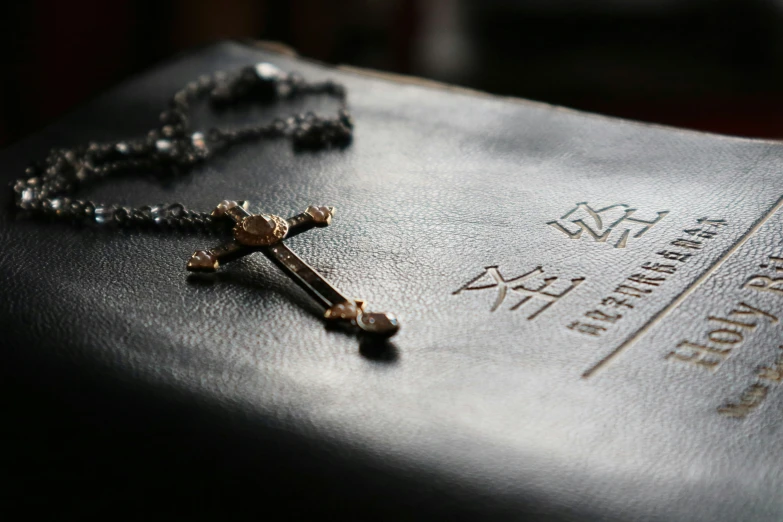 cross sits on the back of an empty black bible