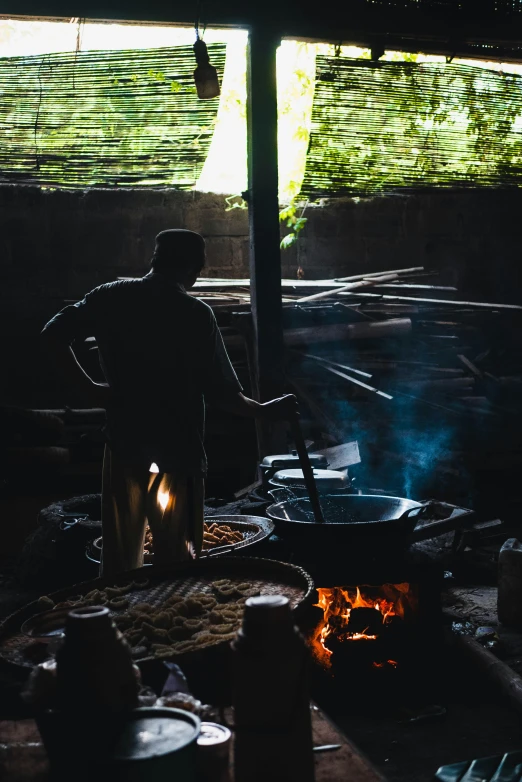 the man is cooking food inside of a small campfire