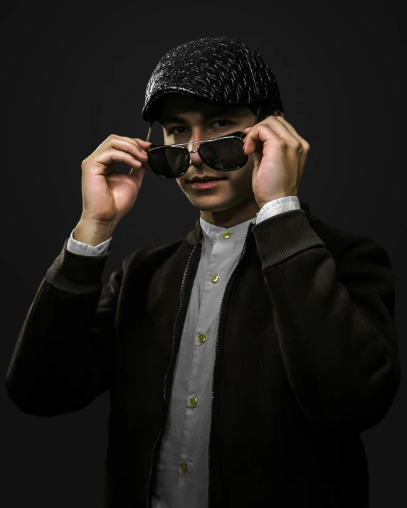 a man wearing a suit and tie holds his sunglasses in front of him