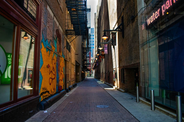 a narrow brick sidewalk with graffiti on the sides