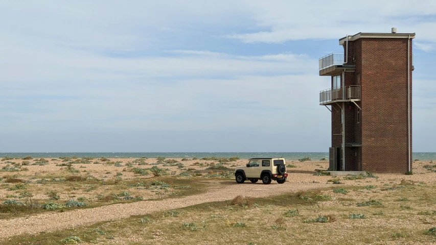 two jeeps parked next to a tall tower