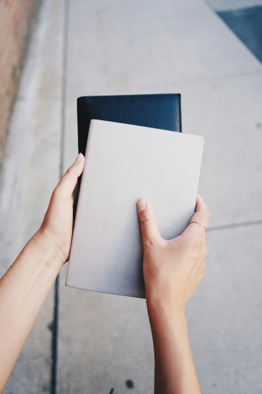 a person holding up an item with a book inside