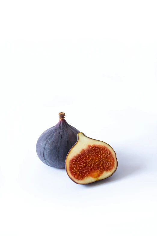 some cut figs with white background with a single cut fig