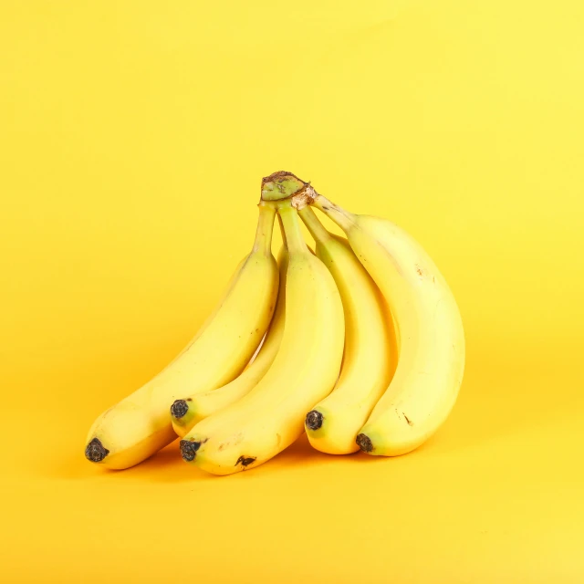 some very ripe bananas that are on a yellow table