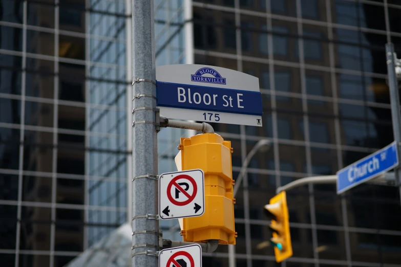 street signs sit under a traffic light at the intersection